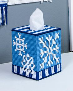 a tissue dispenser is decorated with blue and white snowflakes