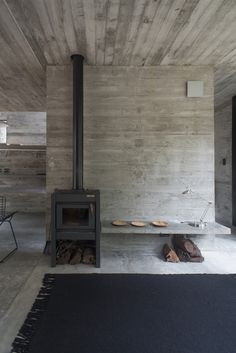 a room with a fireplace and some shoes on the floor next to an area rug