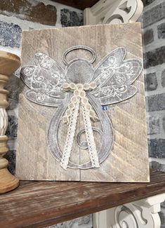 a wooden plaque with an angel design on it