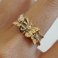 "With brave wings, she flies..."The "Butterfly Hope ring" ring is inspired by the beauty and endurance of butterflies. It symbolizes personal transformation, hope, and rebirth. Three gold butterflies sit on a 14K solid gold band, embellished with your choice of tiny white diamonds. Handcrafted in 14K solid yellow gold, rose gold and white gold. 14K solid gold Natural round white diamonds. SI clarity. Approx 0.035ct 1.2mm ring band **This item is specially made for you. Please allow 1-2 week lead Gold 14k Butterfly Shaped Ring, Yellow Gold Butterfly Ring With Diamond Accents As Gift, Gold Butterfly Ring With Diamond Accents, Elegant Yellow Gold Butterfly Ring, Gold 14k Butterfly Ring, With Brave Wings She Flies, Brave Wings, Personal Transformation, Solid Gold Band