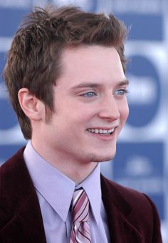 a young man in a suit and tie smiling