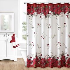 a red and white shower curtain with flowers on it in a bathroom next to a toilet