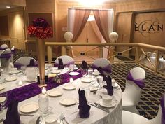 the tables are set with white and purple linens