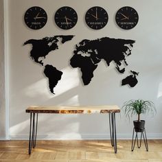 three clocks mounted to the wall above a table