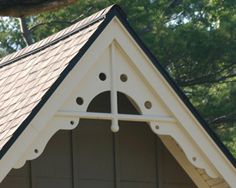 a dog house that has a clock on the front and side of it, with trees in the background