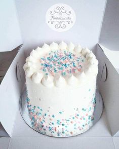 a white cake with sprinkles in a box