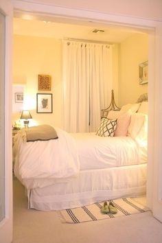 a bedroom with a bed, rugs and pictures on the wall in it's doorway