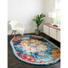 a blue rug with an orange and red floral design on it in front of a white brick wall