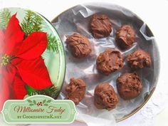 there is a tin with chocolates in it and a red flower next to it