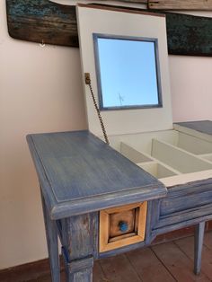 an old blue table with a mirror on it