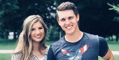 a young man and woman standing next to each other in front of some green grass