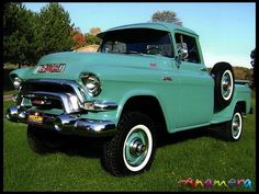 an old pick up truck parked in the grass