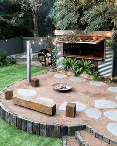 an outdoor kitchen is built into the side of a backyard with grass and stepping stones