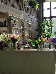 the flowers are in vases on the counter at the flower shop's front desk