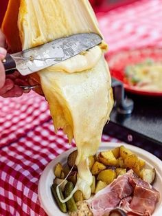 someone is cutting up food in a bowl on a table with a red and white checkered tablecloth