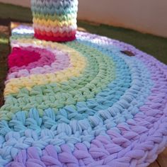 a crocheted table cloth on top of a wooden table with a vase in the middle