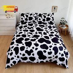 a black and white cow print comforter on a bed