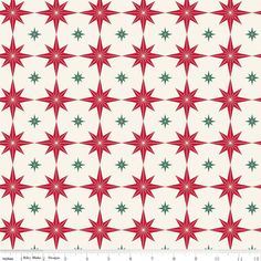 a red and green star pattern on white fabric with a ruler in the foreground