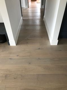 an empty hallway with hard wood floors and white walls