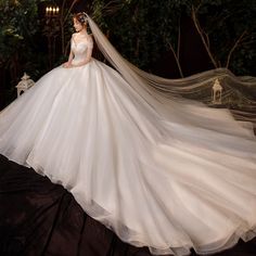 a woman in a wedding dress is standing on a stage with her veil flying around