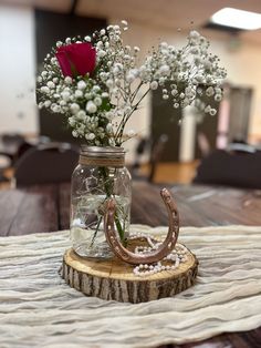 a vase filled with flowers sitting on top of a wooden table next to a horseshoe