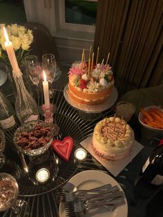 a table topped with two cakes covered in frosting and surrounded by other desserts