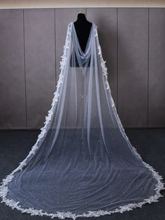 a white veil on a mannequin headdress in front of a wall