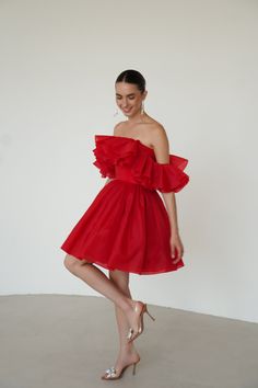 a woman in a red dress posing for the camera with her hand on her hip