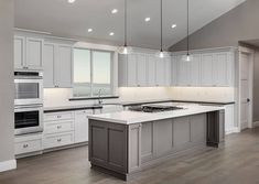 a large kitchen with white cabinets and an island in front of the stove top oven