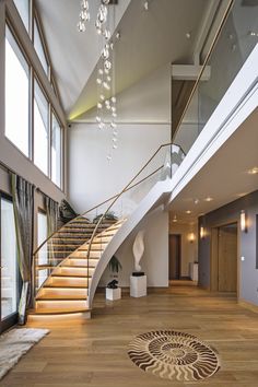 a large open floor plan with stairs and chandelier