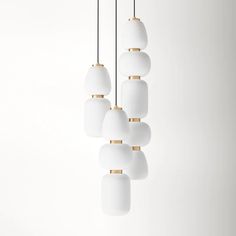 a group of white and gold lights hanging from a ceiling fixture in an empty room