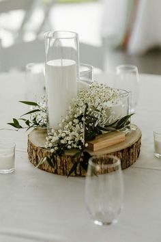 the centerpiece is made out of wood and glass vases with flowers on them