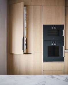 an oven built into the side of a wall in a kitchen with marble counter tops