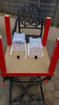 two plastic containers sitting on top of a red table next to a black metal chair