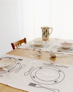 the table is set with dishes and cups