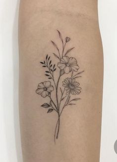 a black and white flower tattoo on the right thigh, with small flowers growing out of it