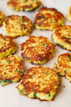 several crab cakes are arranged on a sheet of wax paper and ready to be eaten