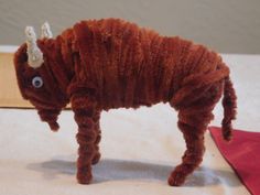 an animal made out of yarn sitting on top of a table