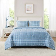 a bed with blue and white comforters in a bedroom