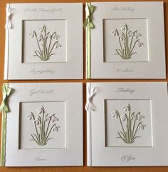 four cards with flowers on them and ribbons tied around the edges, all in white paper