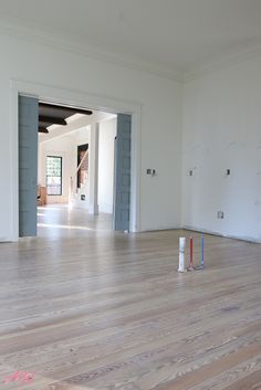 an empty room with blue and white paint on the walls, wood floors and two doors