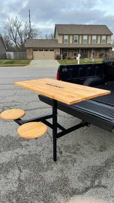 a picnic table sitting in the middle of a parking lot next to a black truck