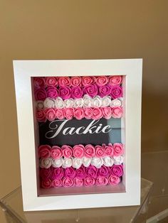 a white frame with pink and white roses in it that says jaclie on the front