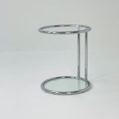 a round glass table with metal legs on a white background