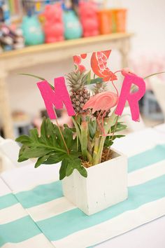 there is a vase with flowers in it and the letters are made out of paper