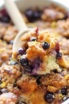 a spoon full of blueberry cobbler with crumbs