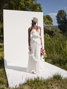 a woman standing in front of a white backdrop