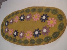 an oval rug with flowers and leaves on it