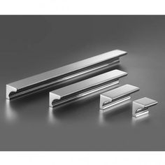 three stainless steel brackets on a gray background