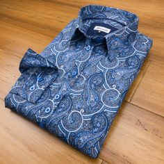 A charming multi-tonal blue paisley on a steel grey background. Blue paisley prints have consistently been some of the most popular designs of Grenouille shirts and it's easy to see why; elegant, understated and incredibly easy to match with. We kept the overall design for this shirt simple, with accessories and piping in matching blue shades. Made in our relaxed fit style and with a 2 button adjustable size cuff; no darts, but very slightly shaped for a feminine look. Details: - 100% cotton pop Blue Paisley Print Long Sleeve Shirt, Classic Blue Paisley Print Tops, Blue Cotton Tops With Paisley Print, Fitted Blue Printed Shirt, Blue Fitted Top With Paisley Print, Fitted Blue Top With Paisley Print, Classic Paisley Print Patterned Tops, Classic Patterned Tops With Paisley Print, Classic Patterned Top With Paisley Print